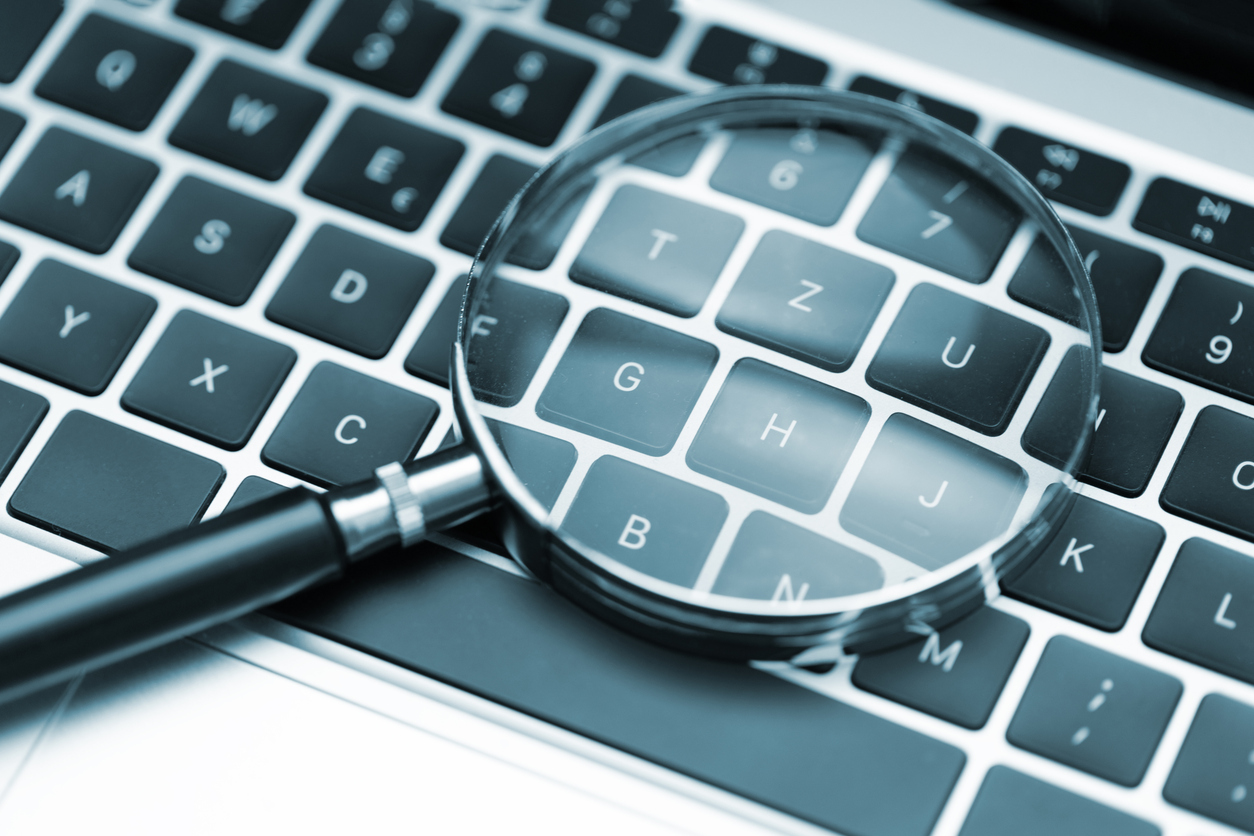 keyboard keys under magnifying glass when searching how to select SEO keywords