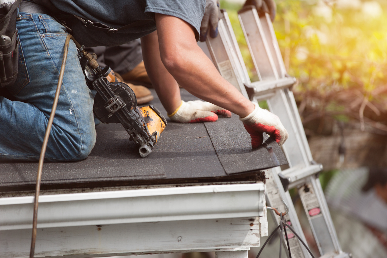 roofing contractor on roof after investing in roofing marketing