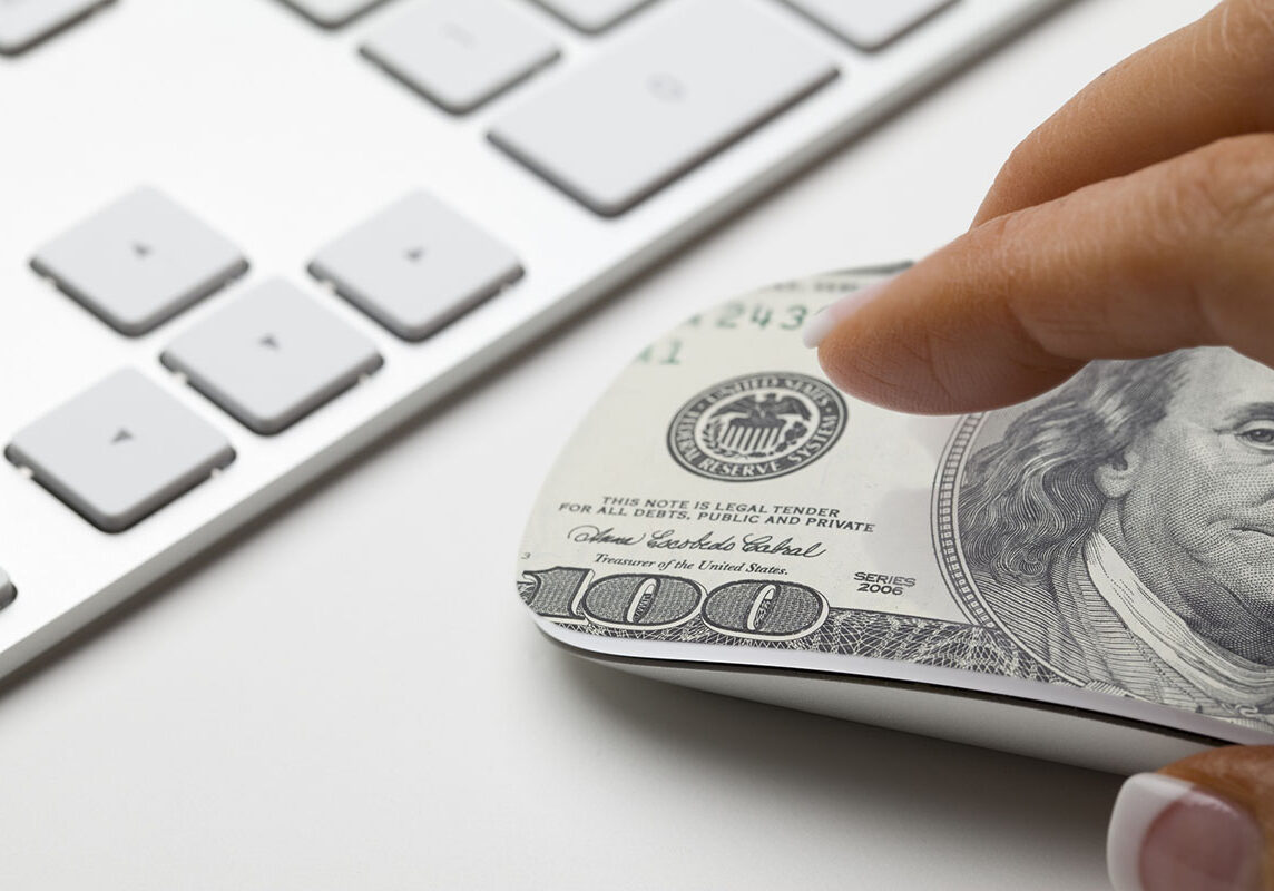 Hand on mouse with 100 dollar bill on it. Concept for affiliate marketing or e-commerce.